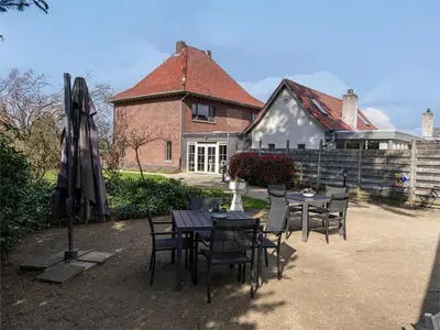 a table and chairs in front of a house at De Kievelder in Peer
