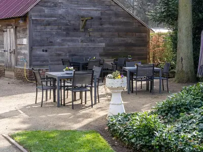 a group of tables and chairs in a yard at De Kievelder in Peer