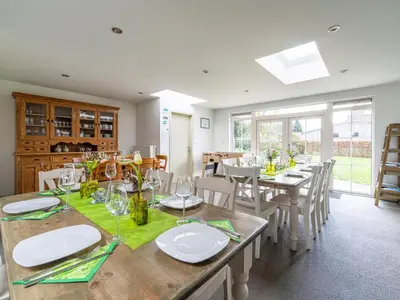 a dining room with wooden tables and chairs and windows at Secretarishuis in Peer