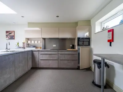 a kitchen with gray cabinets and a window at Secretarishuis in Peer
