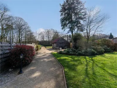a garden with a path and a tree and a building at Het Bruegelhof in Peer