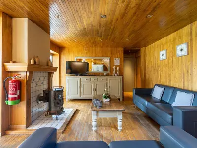 a living room with a blue couch and a fireplace at Het Bruegelhof in Peer