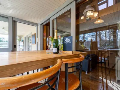 a kitchen with a wooden bar with two chairs at Het Bruegelhof in Peer