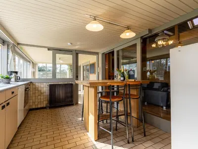 a kitchen with a bar with stools in it at Het Bruegelhof in Peer
