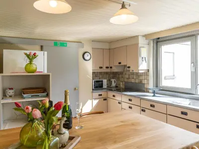 a kitchen with a wooden table and a window at Het Bruegelhof in Peer