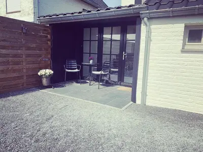 a patio with chairs and a table in a house at Vakantiewoning Mèzik in Maasmechelen