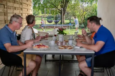 a group of people sitting around a table eating food at Vakantiewoning Mèzik in Maasmechelen