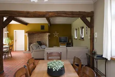a living room with a table and a couch at Glabbeek-hoeve in Geetbets