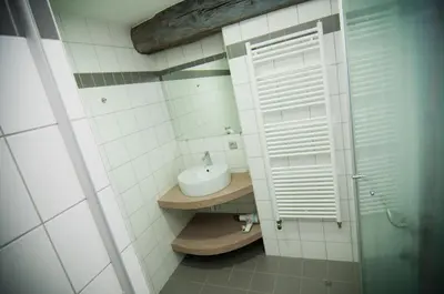 a white bathroom with a sink and a window at Apartment De Maasnacht in Maaseik