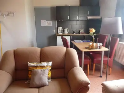 a living room with a couch and a table at De Alpacaboerderij in Bocholt