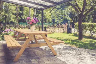 a picnic table and bench with a vase of flowers on it at Landhuisjes Bij De Wouterbron in Oudsbergen