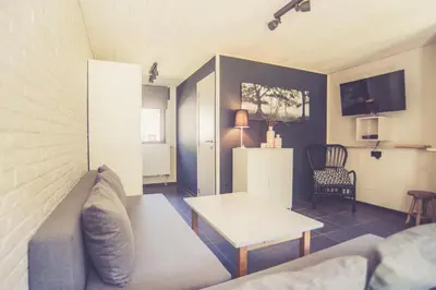 a living room with a couch and a table at Landhuisjes Bij De Wouterbron in Oudsbergen