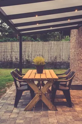 a wooden picnic table with a potted plant on it at Landhuisjes Bij De Wouterbron in Oudsbergen