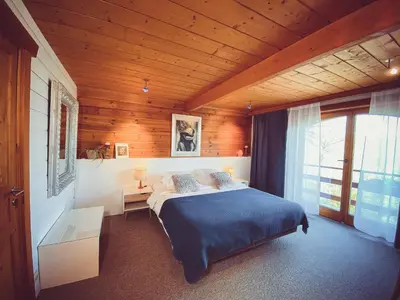 a bedroom with a bed and a wooden ceiling at Nîdwazô - Ecolodge & Maison d'hôtes in Trooz