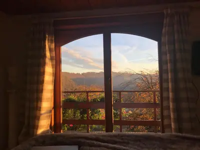 a bedroom window with a view of the mountains at Nîdwazô - Ecolodge & Maison d'hôtes in Trooz