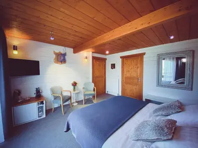 a bedroom with a bed and a table and chairs at Nîdwazô - Ecolodge & Maison d'hôtes in Trooz