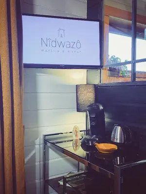 a glass table with a coffee maker and a television at Nîdwazô - Ecolodge & Maison d'hôtes in Trooz