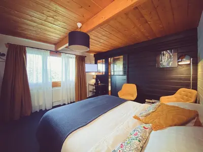 a bedroom with a large bed and two chairs at Nîdwazô - Ecolodge & Maison d'hôtes in Trooz