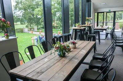 a large room with tables and chairs and windows at De Zwaluwhoeve in Peer