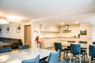 a kitchen and a living room with a table and chairs at De Zwaluwhoeve in Peer