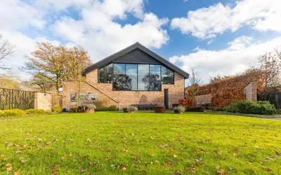a house with a large window on top of a yard at De Zwaluwhoeve in Peer
