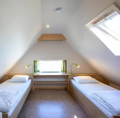 two beds in a room with a window at Holiday Home Op 't Busselen in Opoeteren