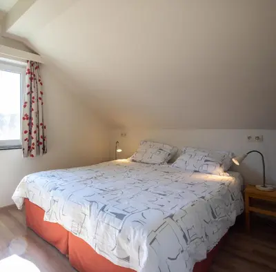 a bedroom with a large bed with white sheets at Holiday Home Op 't Busselen in Opoeteren