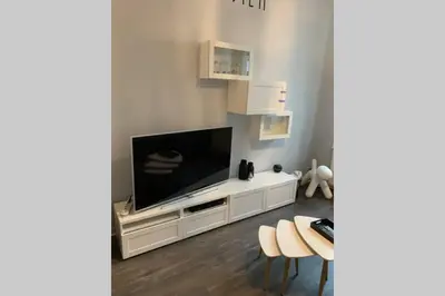 a living room with a television on a white entertainment center at Duplex 90m Centre Verviers Calme Gare à pied Spa Francorchamps 20 min in Verviers