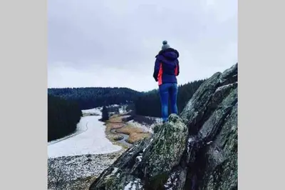 a person standing on a rock looking at a river at Duplex 90m Centre Verviers Calme Gare à pied Spa Francorchamps 20 min in Verviers