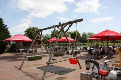 a playground with red umbrellas and tables and chairs at Viva La Vie in Maaseik