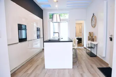 a kitchen with white cabinets and a black counter top at SuiteDreams - Bubble Suite Liège in Liège