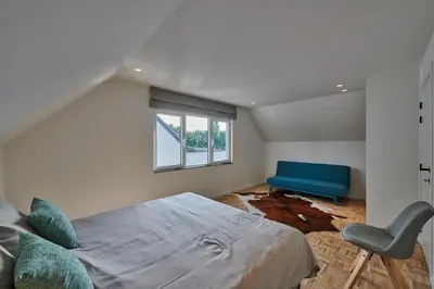 a bedroom with a bed and a blue chair at Vakantiehuis Sahara119 in Lommel