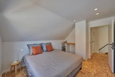 a bedroom with a large bed with orange pillows at Vakantiehuis Sahara119 in Lommel