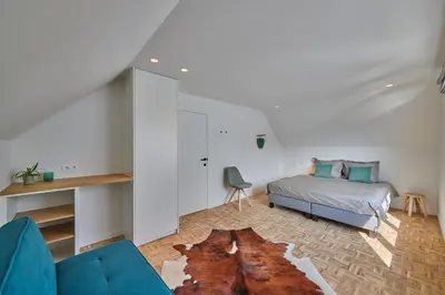 a living room with a bed and a couch at Vakantiehuis Sahara119 in Lommel
