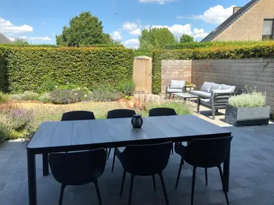 a black table and chairs on a patio at Hof van Eggertingen nr. 8 in Riemst