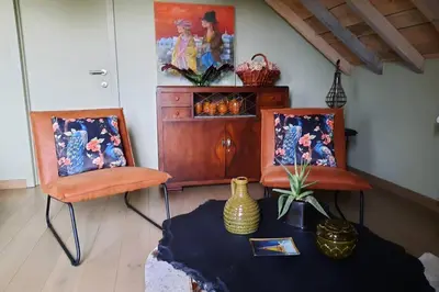 two chairs in a room with a table and a painting at Hof van Eggertingen Bakhuis in Riemst
