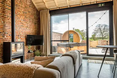 a living room with a couch and a large window at De Hoeveschuur in Riemst