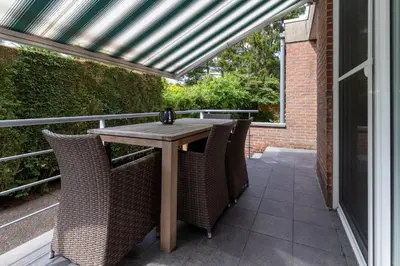 a patio with a table and chairs on a balcony at Vakantiehuis Salamander Maasmechelen in Maasmechelen