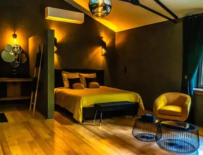 a bedroom with a bed and a chair and a table at Paradis Secret in Beyne-Heusay