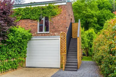 a house with a garage door and a staircase at Paradis Secret in Beyne-Heusay
