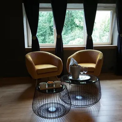 a living room with two chairs and two tables at Paradis Secret in Beyne-Heusay