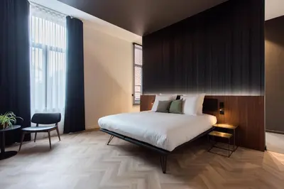 a bedroom with a bed and a large window at Vinotel X in Tongeren