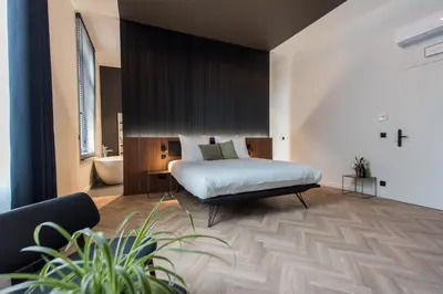 a bedroom with a bed and a bath room at Vinotel X in Tongeren