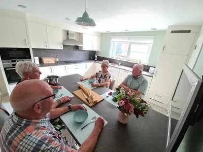 a group of people sitting at a table in a kitchen at Prinsheerlyck in As
