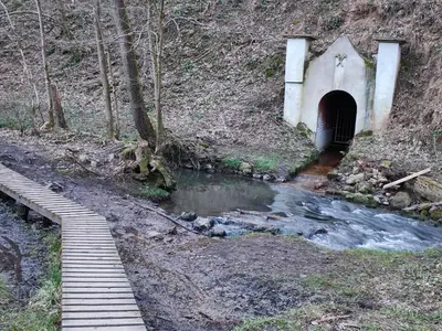 a tunnel in the side of a hill next to a stream at Your Stay in Kelmis - La Calamine- Cosy apartment in the Ardennes -Three-country point - Neu-Moresnet in Kelmis