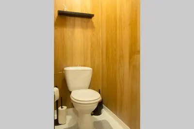 a bathroom with a white toilet in a wooden wall at 'T ONDERDAK in Lommel