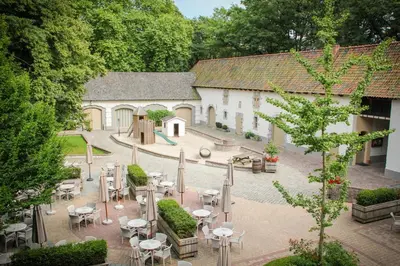 a courtyard with tables and chairs and a building at Factorij10 in Peer