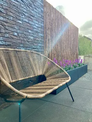a bench sitting in front of a brick wall with a fountain at B&B La Miniera in Genk