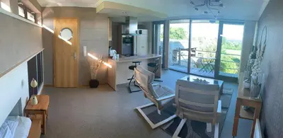 a room with a kitchen and a table and chairs at Le Petit Logis in Jalhay