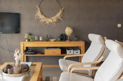 a living room with two white chairs and a table at Le Petit Logis in Jalhay